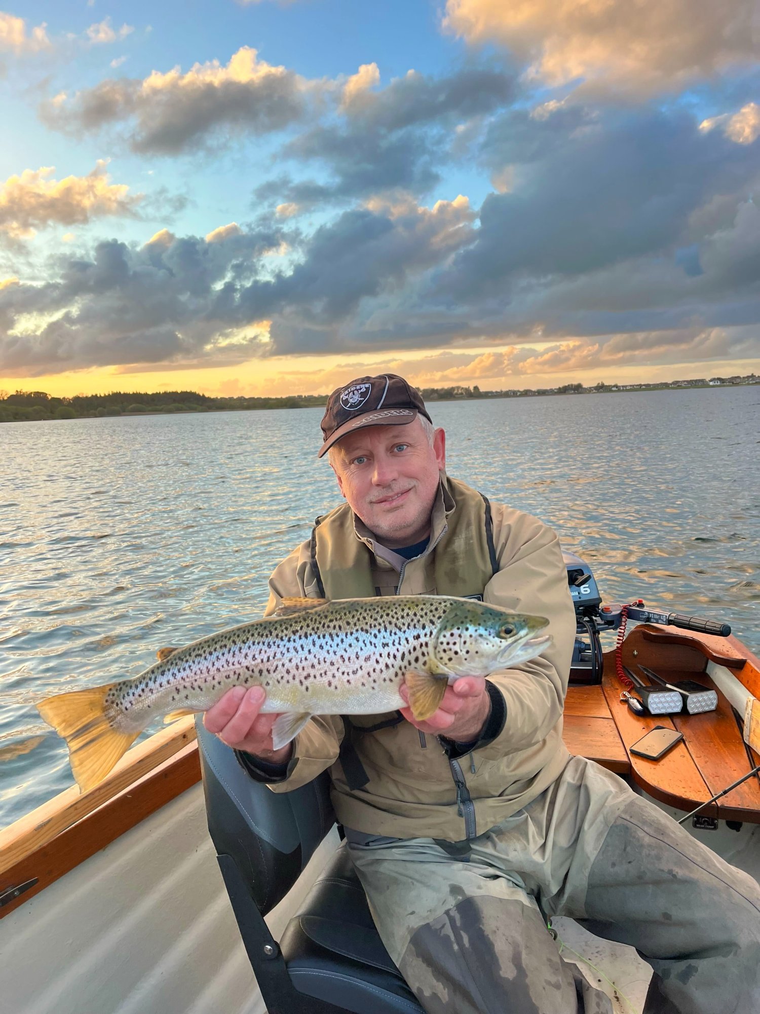 Wild brown trout held over the water at sunset on Lough Rea